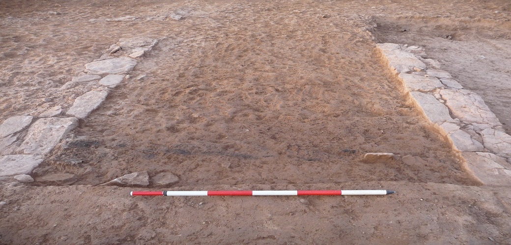 Aspecte de l’accés i del passadís d’entrada a l’edifici des del sud. En primer terme, s’observa el carbó que podria haver format part del tancament de la porta